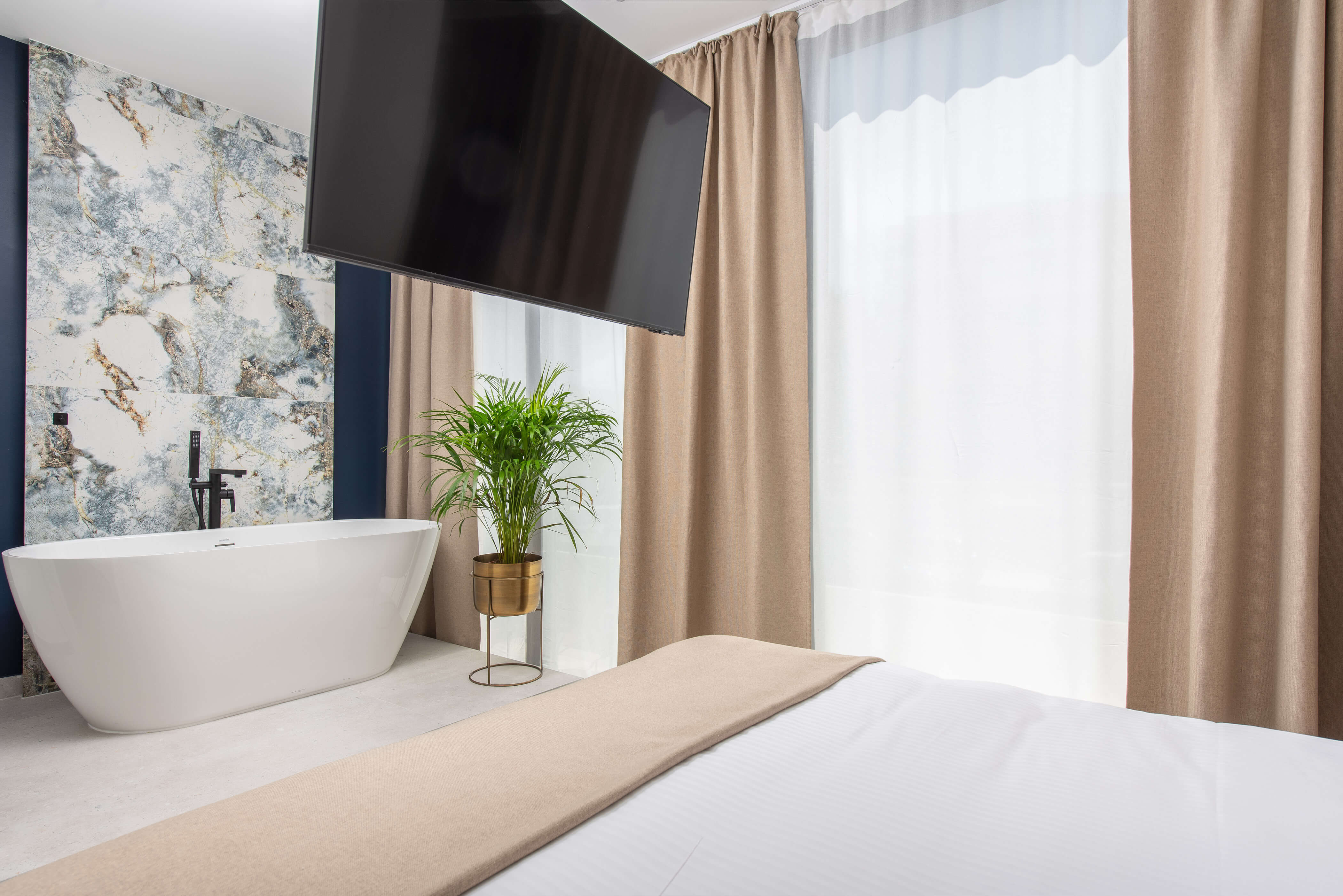 Innenansicht von Samstag ParkZone mit einem Bett und einer freistehenden Badewanne